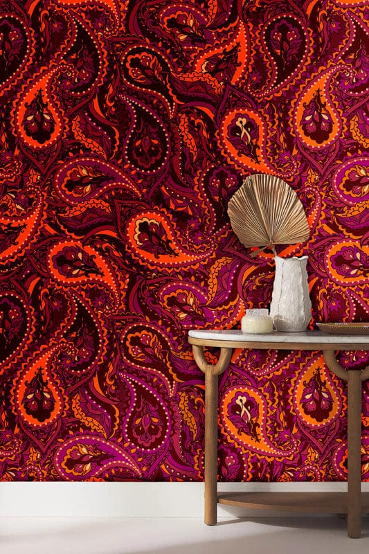 Vibrant Paisley Pattern Wallpaper in rich burgundy, orange, shown with elegant wooden console table.