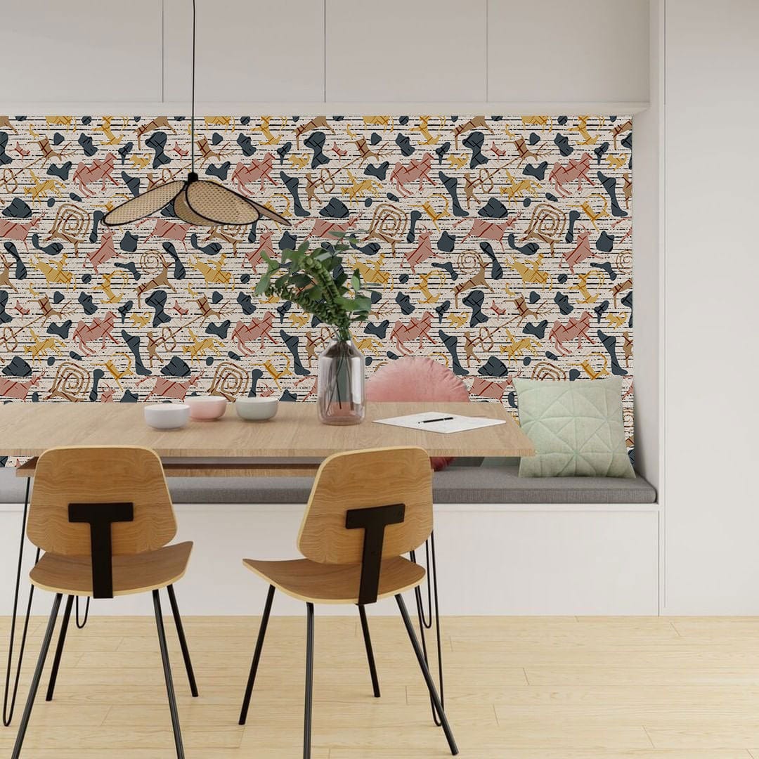 Abstract geometric multi-coloured wallpaper in chic dining room with wooden chairs, light flooring, modern decor.