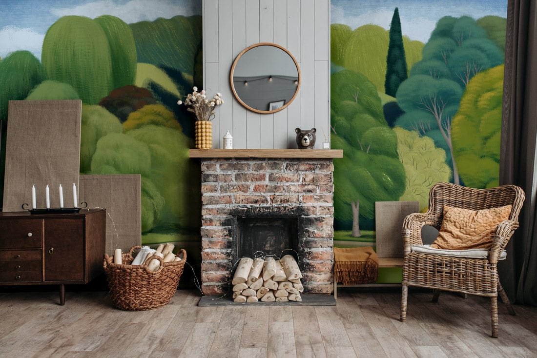 Lush Green Dreamscape mural wallpaper in vintage living room with wicker chair and brick fireplace.