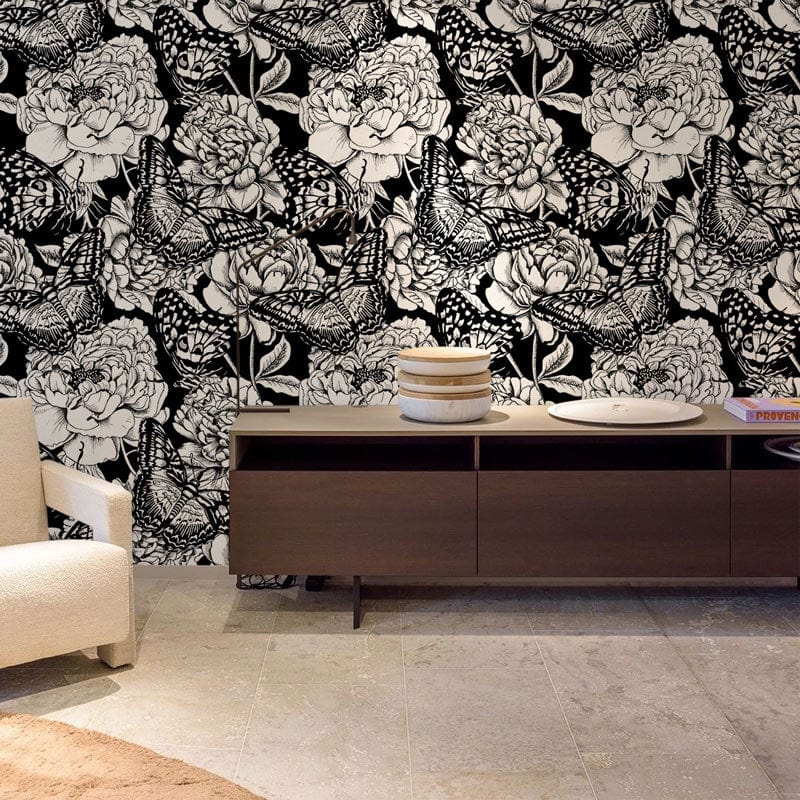 Monochrome butterfly wallpaper in a stylish living room with beige sofa, wooden cabinet, and tiled floor.