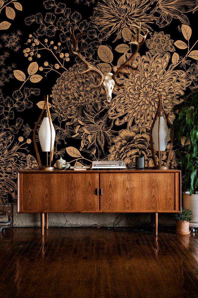 Elegant gold floral wallpaper, vintage wooden sideboard, dark wood flooring, decorative mirrors, deer skull.