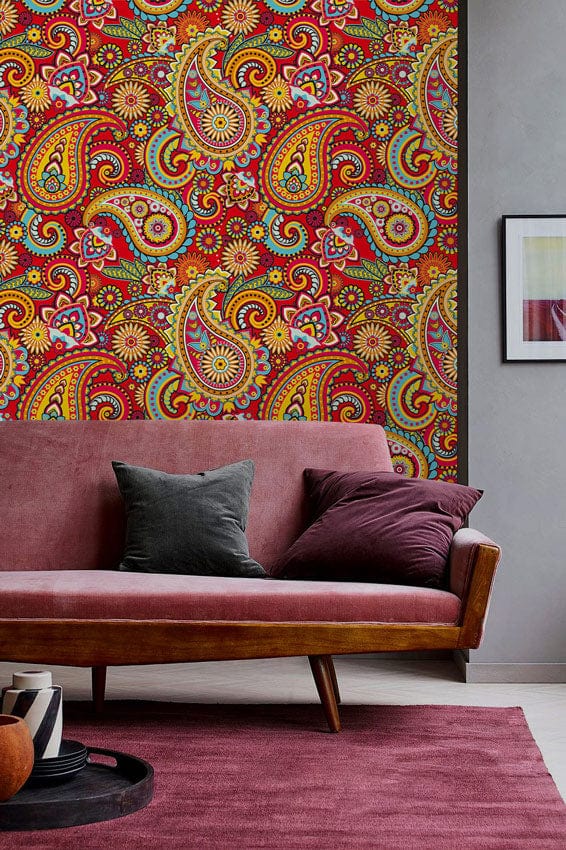Vibrant Paisley Floral Red Wallpaper in bohemian living room with pink sofa, grey wall, and rug.