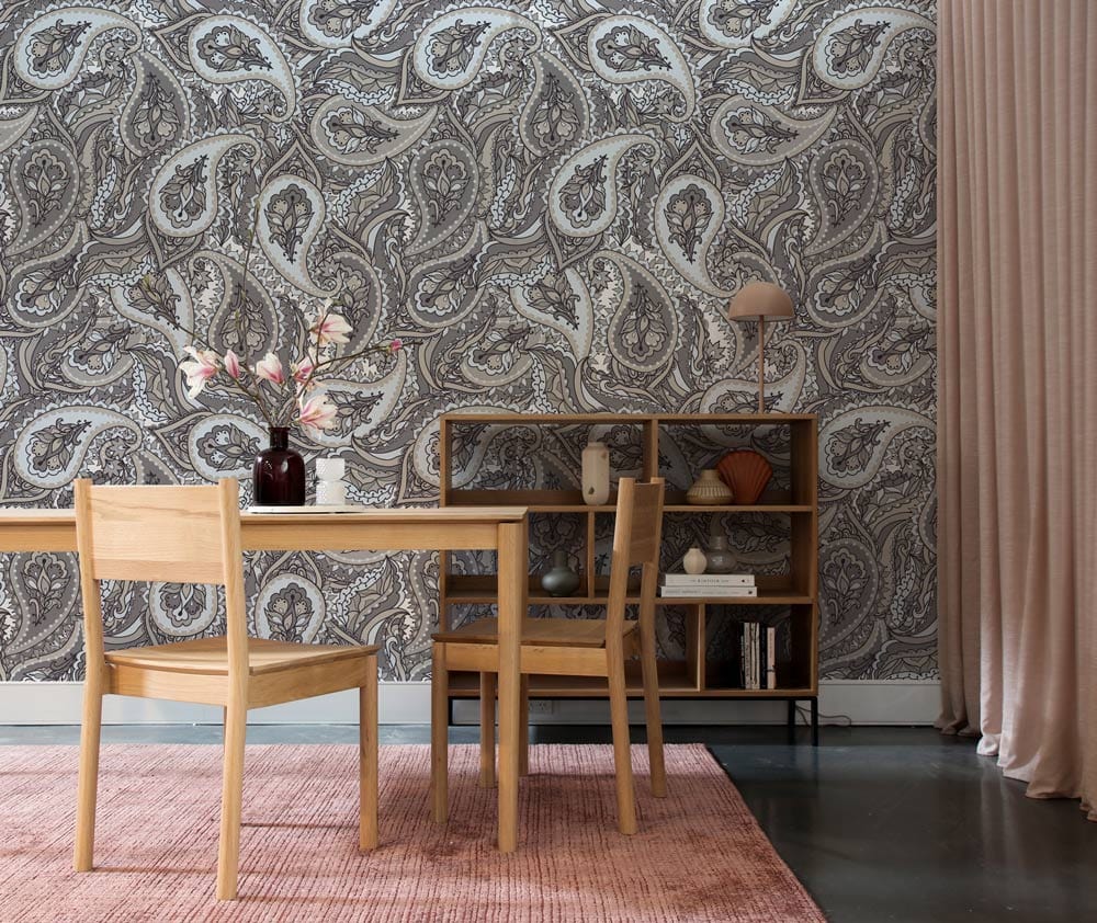 Elegant grey paisley wallpaper in modern dining room with wooden furniture and pink rug Décor.