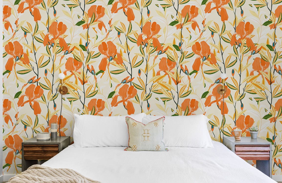 Orange floral wallpaper in bedroom with white bed, wooden side tables, and vibrant botanical design.