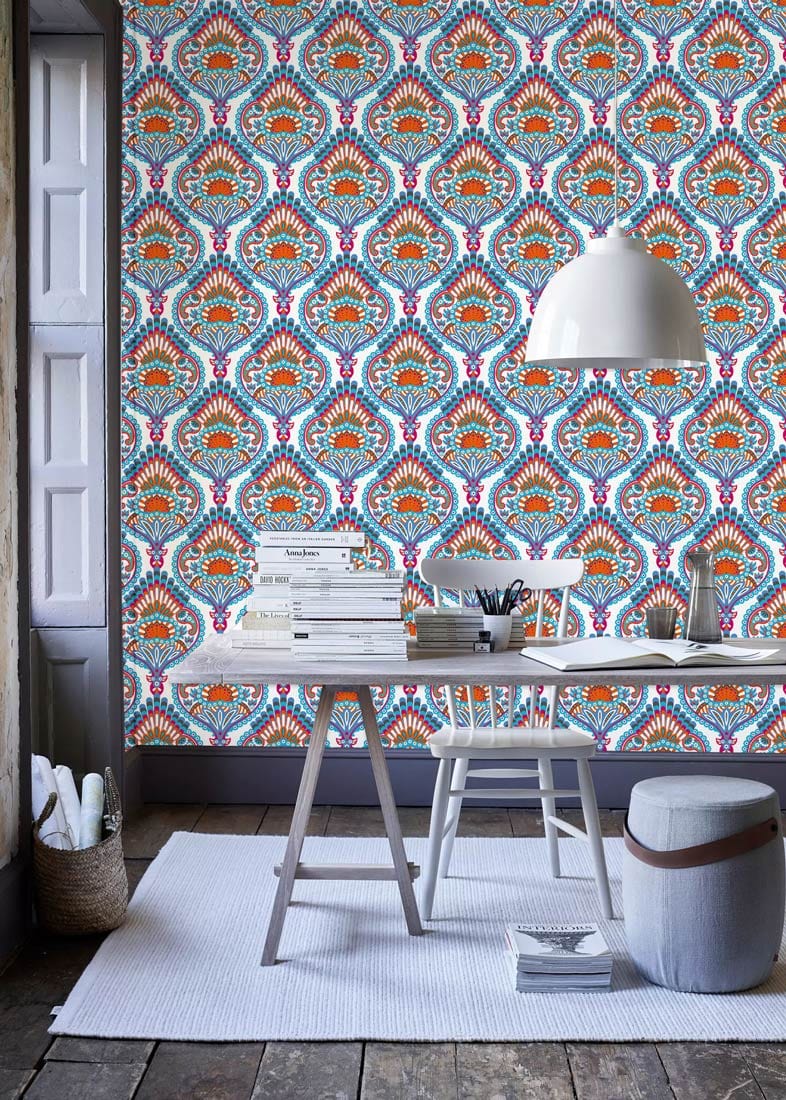 Elegant blue and orange paisley wallpaper, rustic wooden flooring, white rug, stylish grey window shutters.