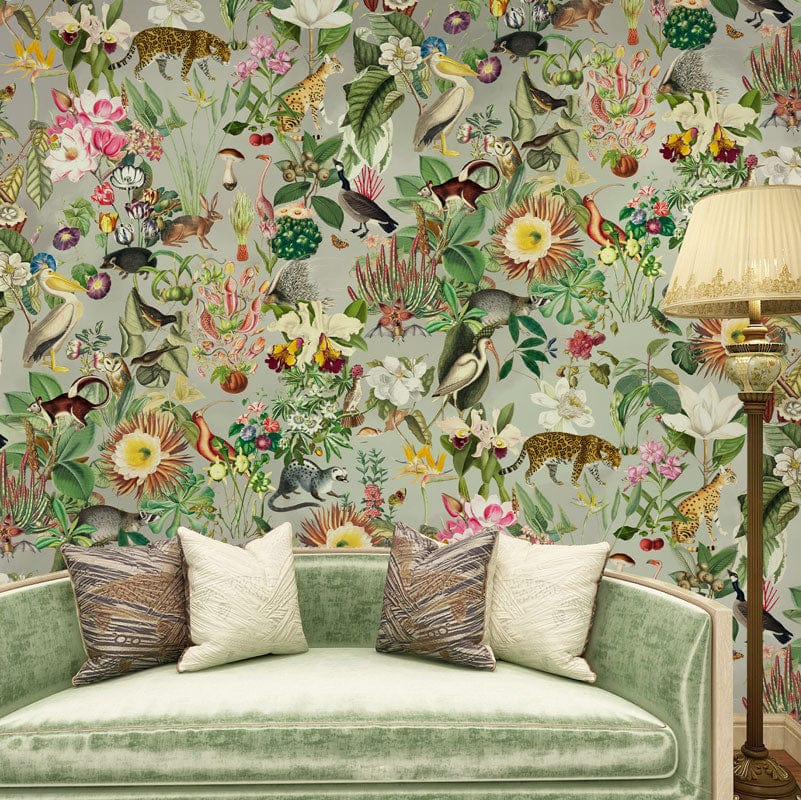 Exotic jungle mural wallpaper with lush flora, wildlife design, green velvet sofa, vintage lamp in lounge.