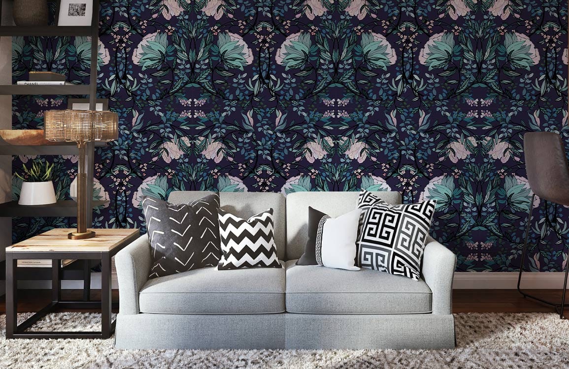 Luxurious botanical teal and midnight floral wallpaper in living room with grey sofa and patterned cushions.