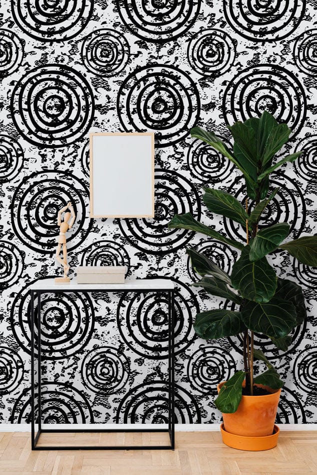 Monochrome Spiral Circles wallpaper, black console table, wooden flooring, fig plant, modern room decor.