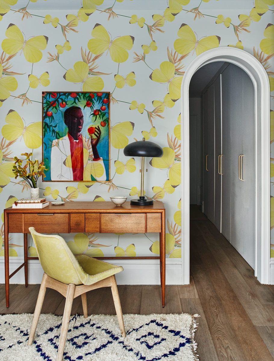 Sunny Yellow Butterfly Bliss mural, nature-theme; mid-century desk, elegant chair, artwork, wood flooring.