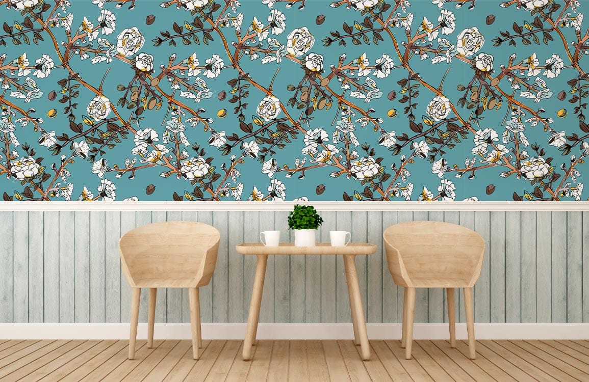 Elegant teal floral wallpaper with white roses, wooden chairs, light-coloured paneling, and pale wood flooring.
