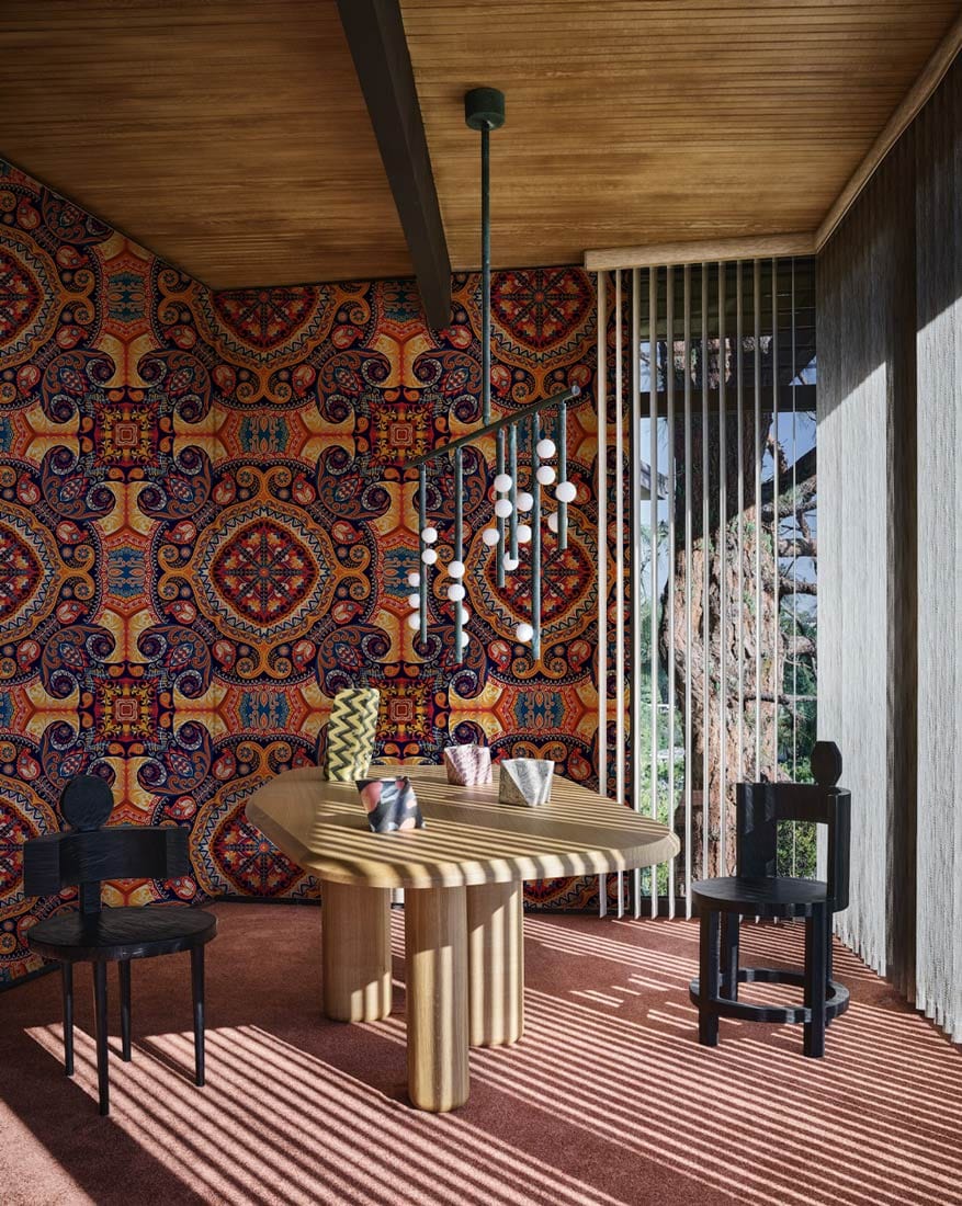 Vintage Bohemian Mandala Pattern Wallpaper in earthy tones, wooden dining table, black chairs, modern pendant.