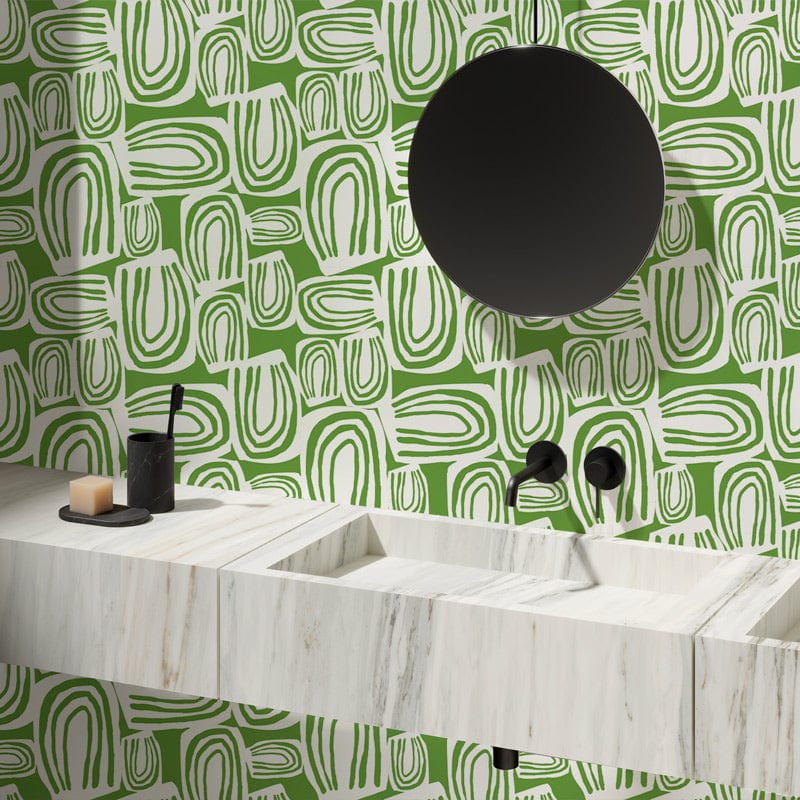 Contemporary geometric wallpaper in green complements minimalist bathroom with marble sink, round mirror, matte fixtures.