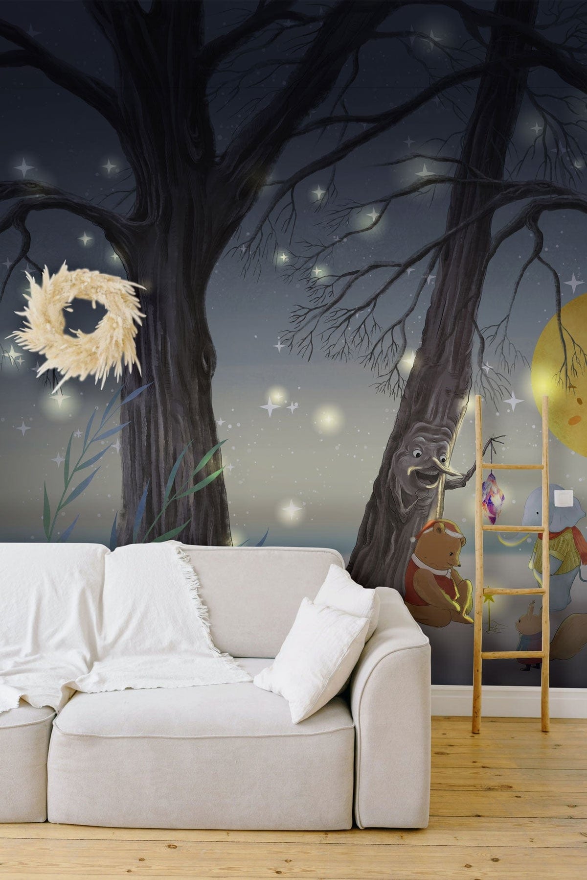 Enchanted woodland wallpaper features night scene with beige sofa, wooden flooring, decorative wreath, ladder shelf.