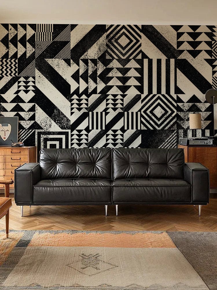 Black leather sofa, monochrome Art Deco wallpaper, modern room, wooden flooring, mid-century sideboard.