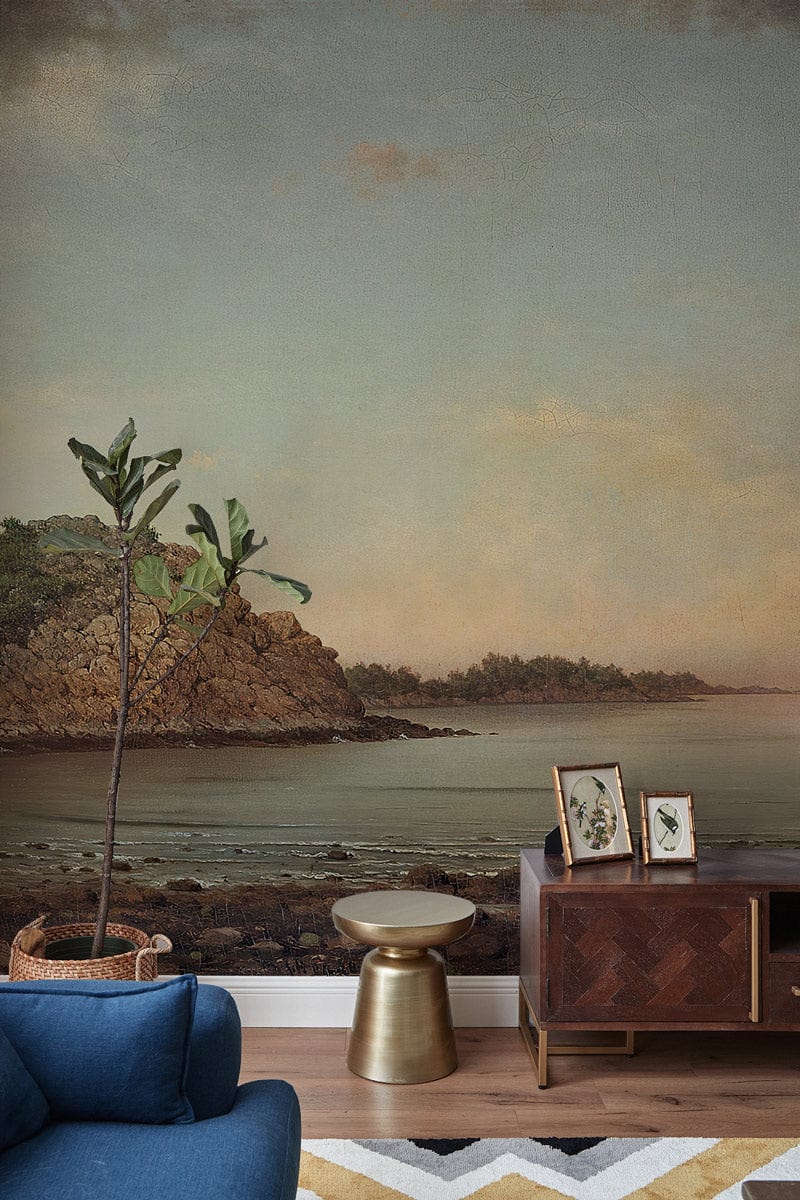 Tranquil Coastal Landscape Mural Wallpaper, pastel hues, blue sofa, wooden flooring, artistic decor.