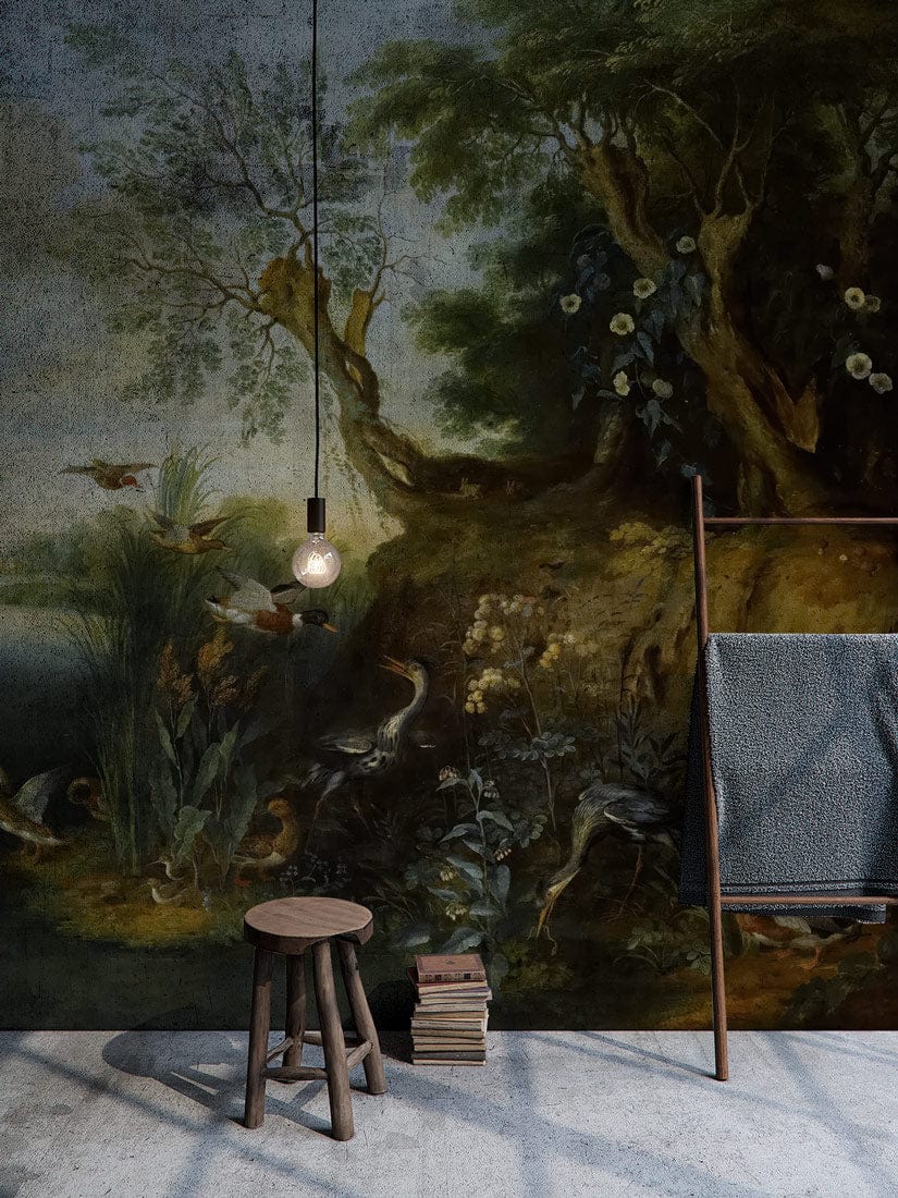 Vintage scenic forest mural wallpaper featuring birds and lake; rustic stool, concrete flooring.
