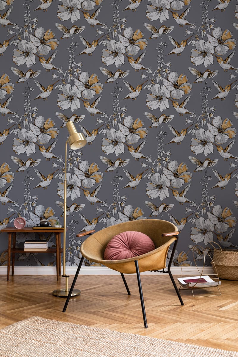 Elegant grey floral wallpaper with butterflies, modern armchair, wooden flooring, and gold floor lamp.
