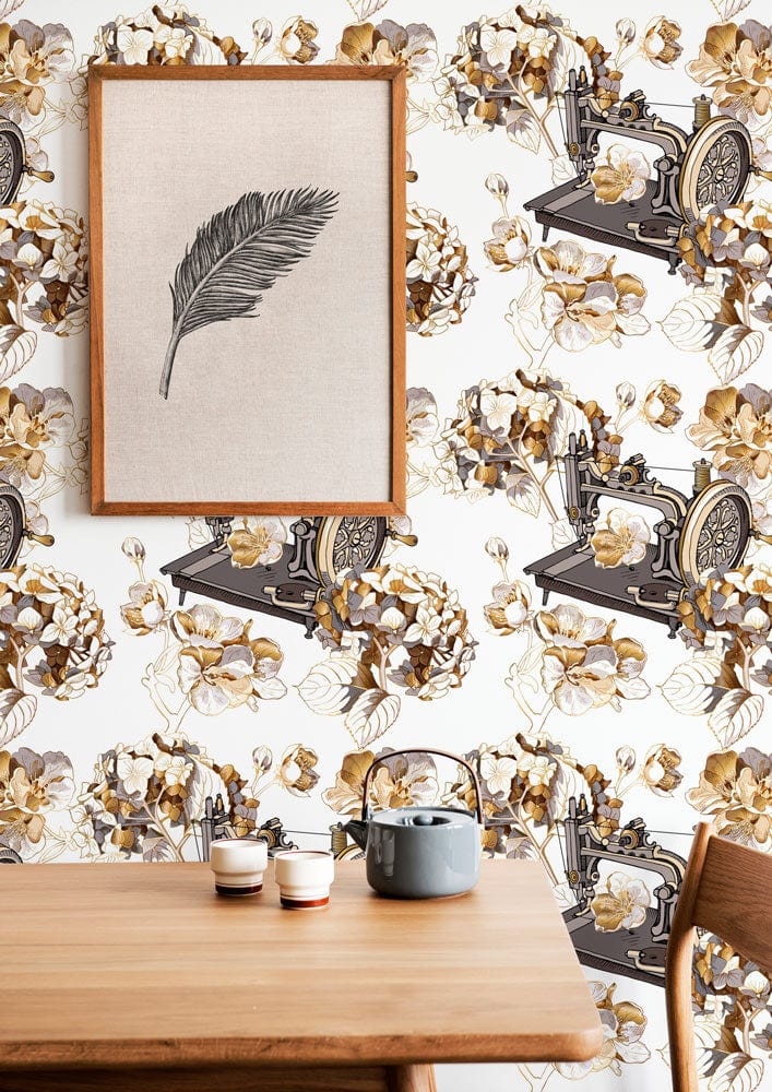 Vintage sewing machine wallpaper in warm tones, floral pattern, wooden table, framed artwork. Classic decor.
