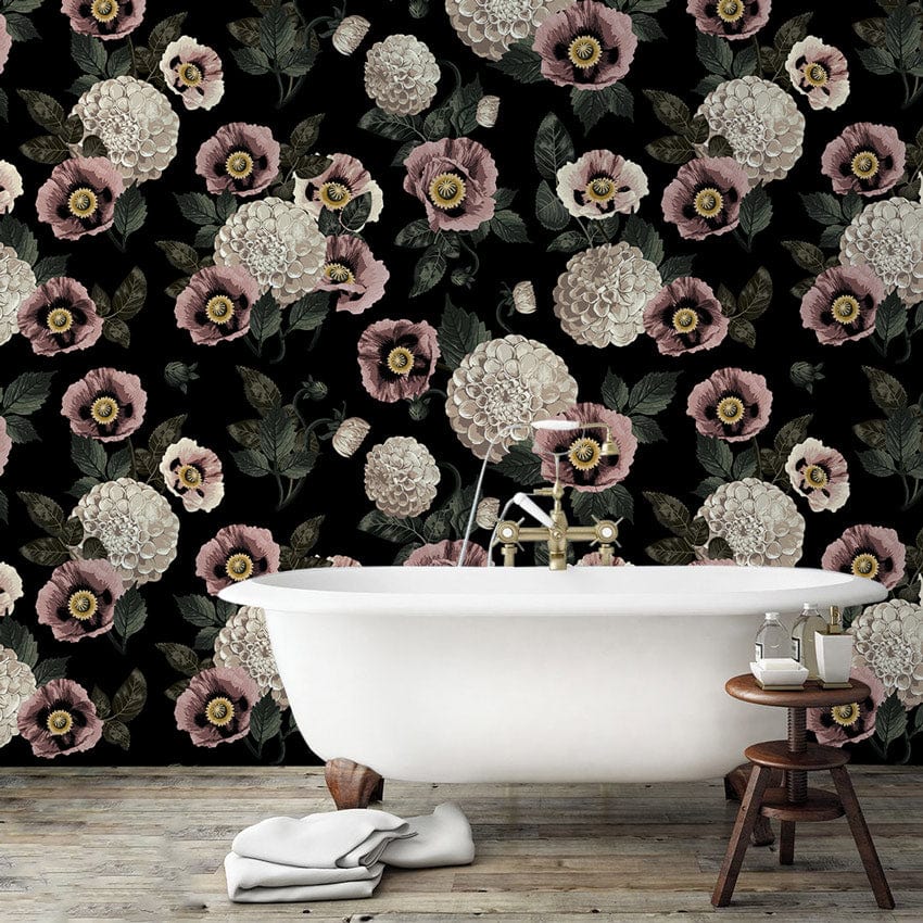 Vintage floral wallpaper in black bathroom with a white bathtub and wooden stool, light wood flooring.