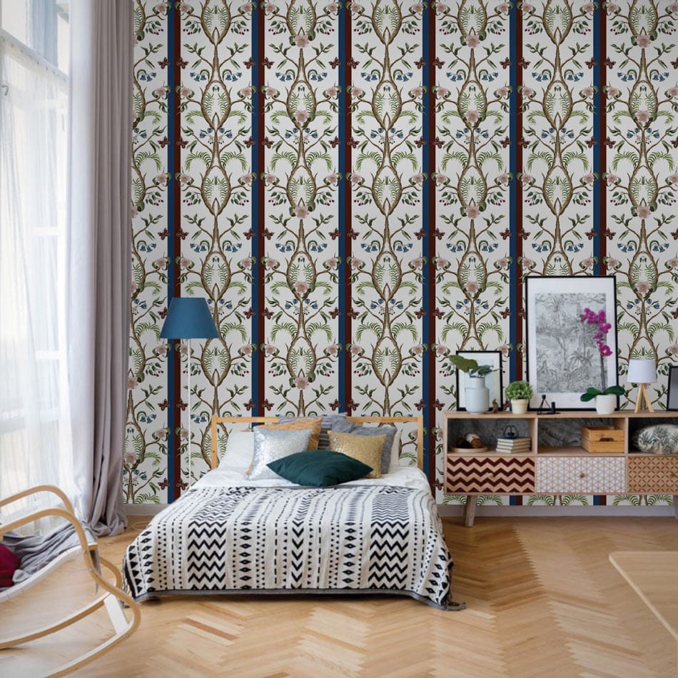 Elegant vintage floral pattern wallpaper in bedroom with chevron flooring, patterned bedspread, and blue lamp.