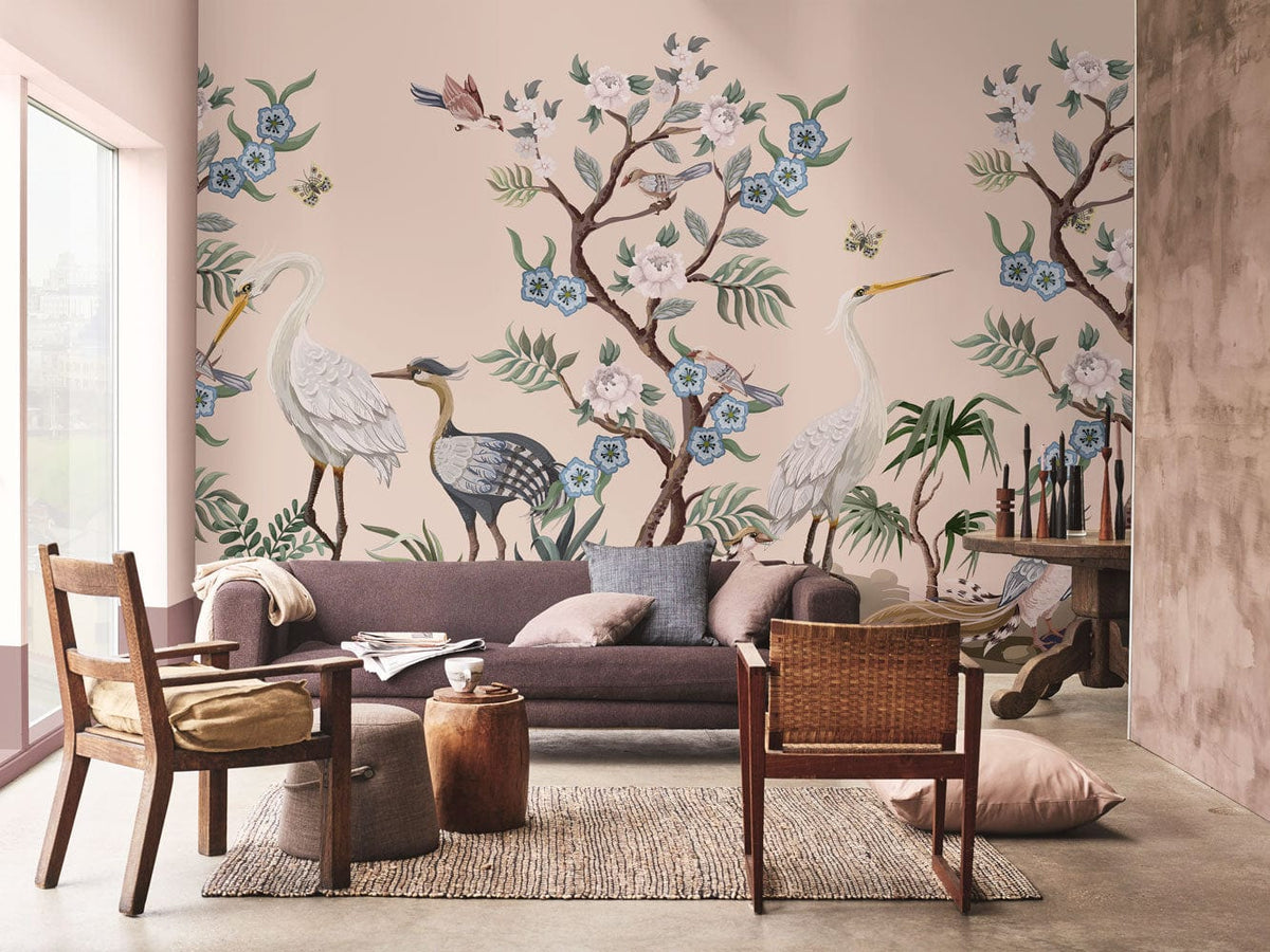 Elegant Heron Mural Wallpaper in pastel; cosy lounge setting with grey sofa, wooden chairs, concrete floor.