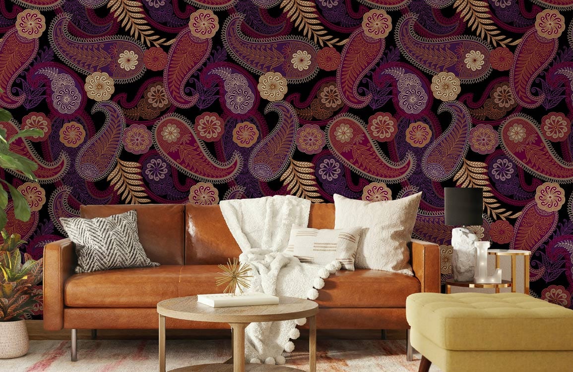 Vintage paisley wallpaper in rich red and gold, with brown leather sofa, colourful cushions, cosy living room.