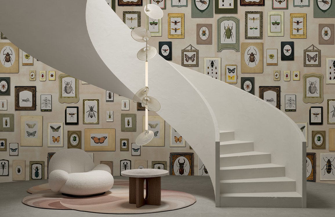 Antique insect mural wallpaper, spiral staircase, beige armchair, circular table, modern room design.
