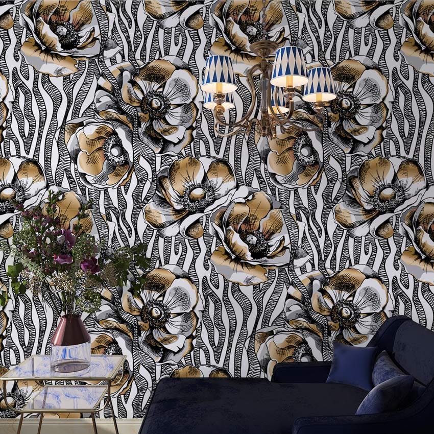Vintage botanical wallpaper with black and gold floral pattern, blue sofa, chandelier, and table.