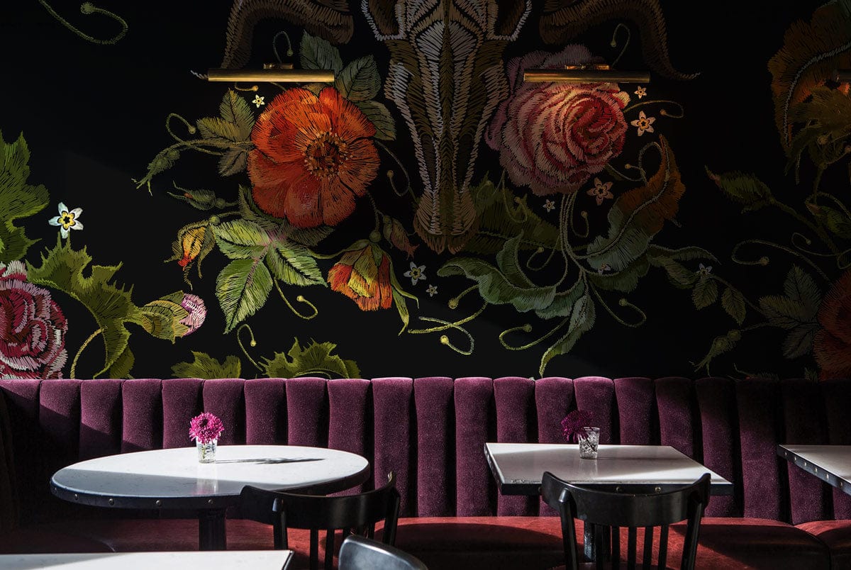 Dark Floral Gothic Skull Wallpaper, vintage botanical pattern; velvet seating, dark walls, café setting.