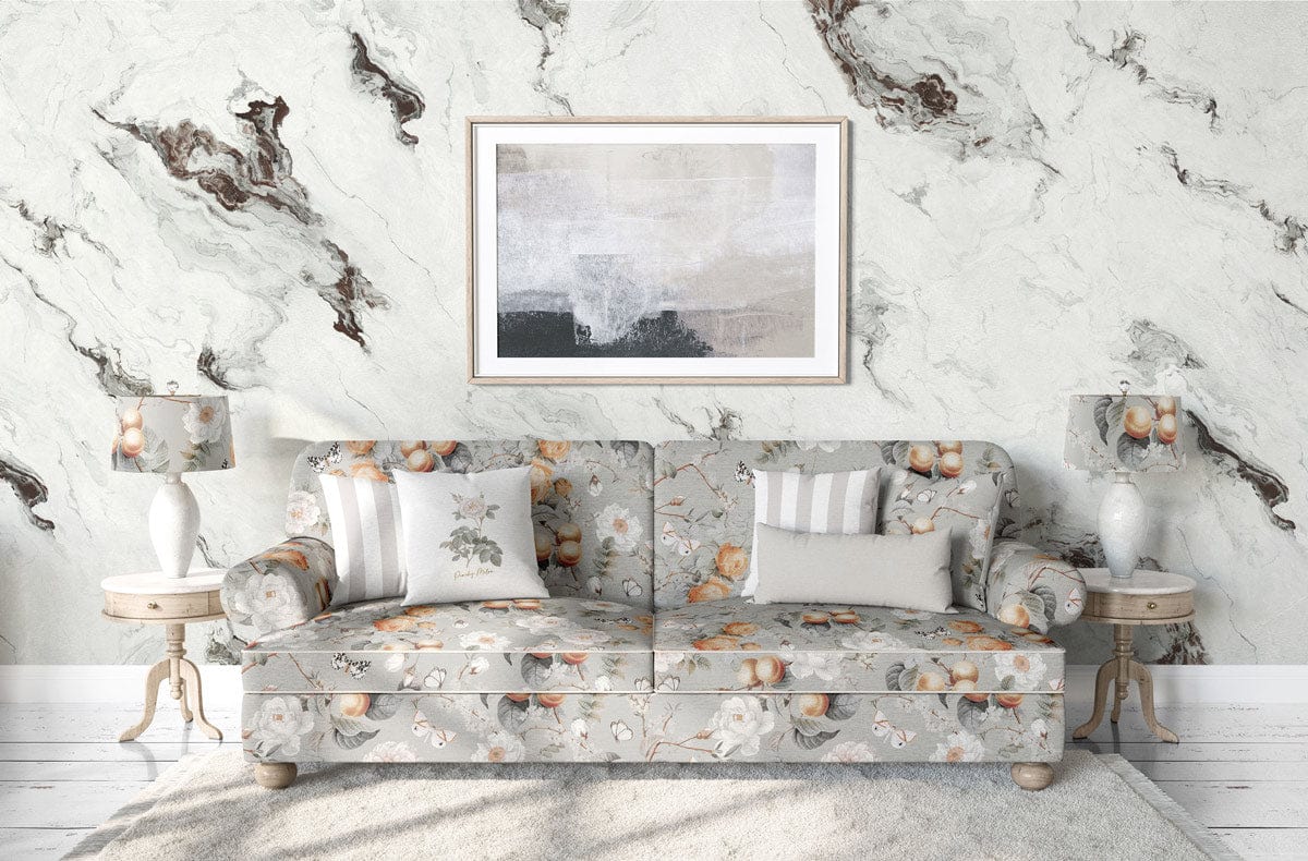 Marble-patterned grey wallpaper in living room with floral sofa, artwork, wooden side tables, and lamps.
