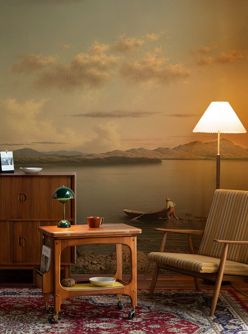 Tranquil Lake Sunset Mural Wallpaper in cosy lounge with vintage furniture, striped chair, warm lighting.