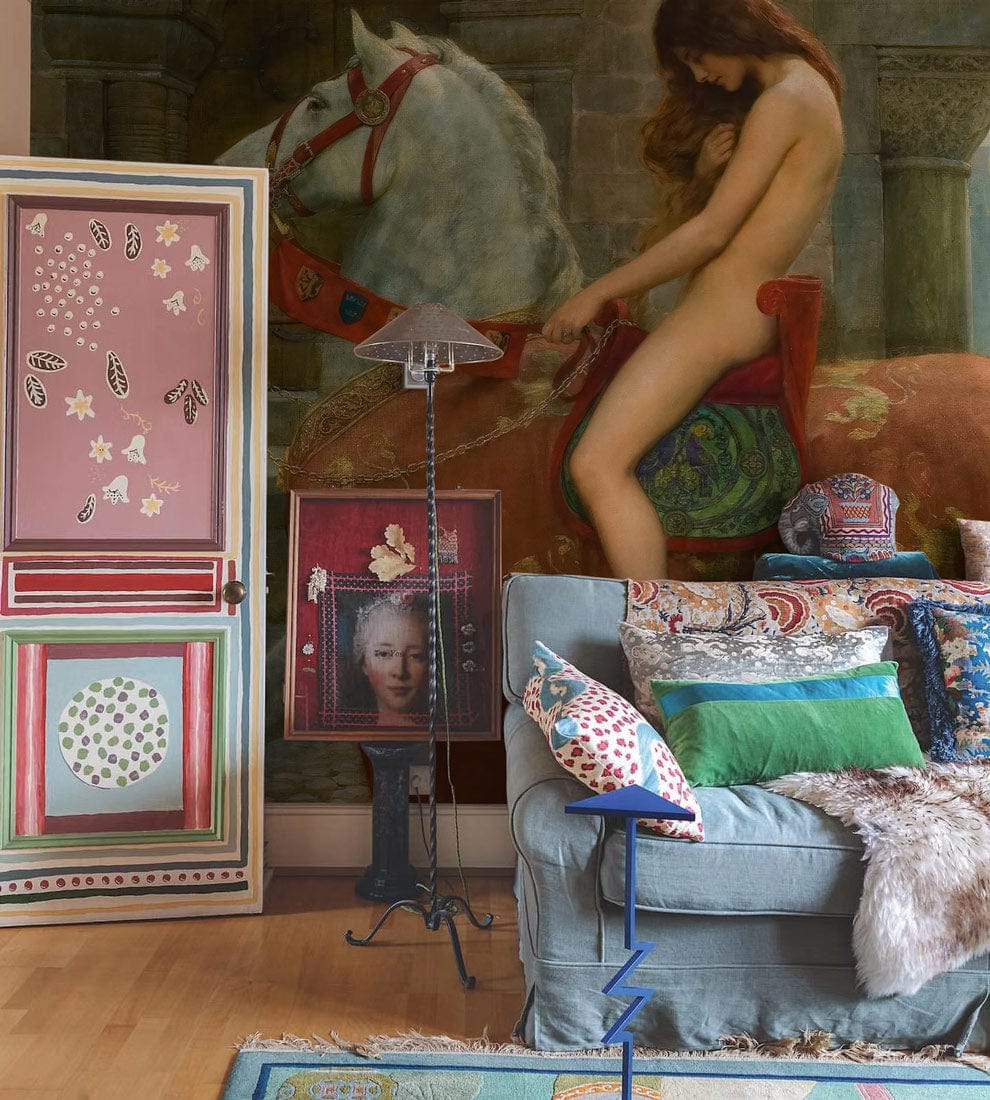 Medieval Lady Godiva mural wallpaper, earthy tones, eclectic living room, colourful cushions, pastel pink door.