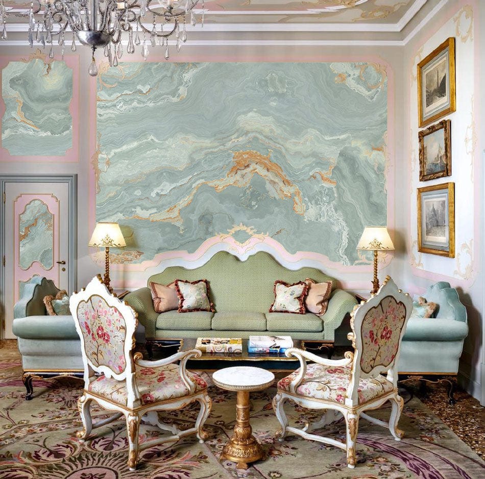 Marble effect wallpaper mural in living room with green sofas, vintage chairs, ornate rug, elegant chandelier.