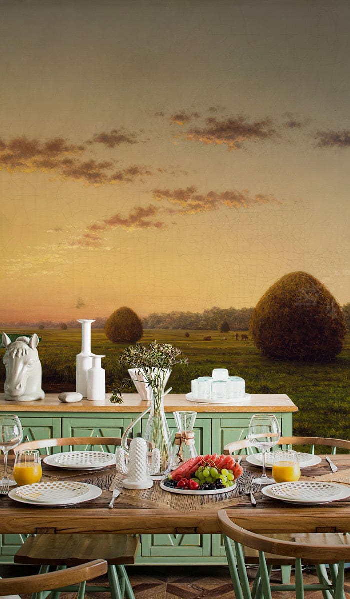 Serene Countryside Sunrise Wallpaper in dining room with wooden table, green sideboard, golden landscape art.