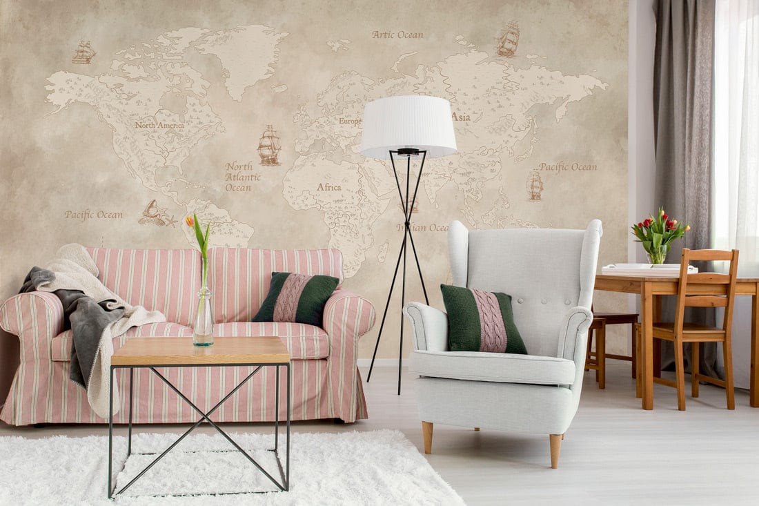 Vintage world map mural wallpaper, sepia tones; pink striped sofa, white armchair, dining table setup.