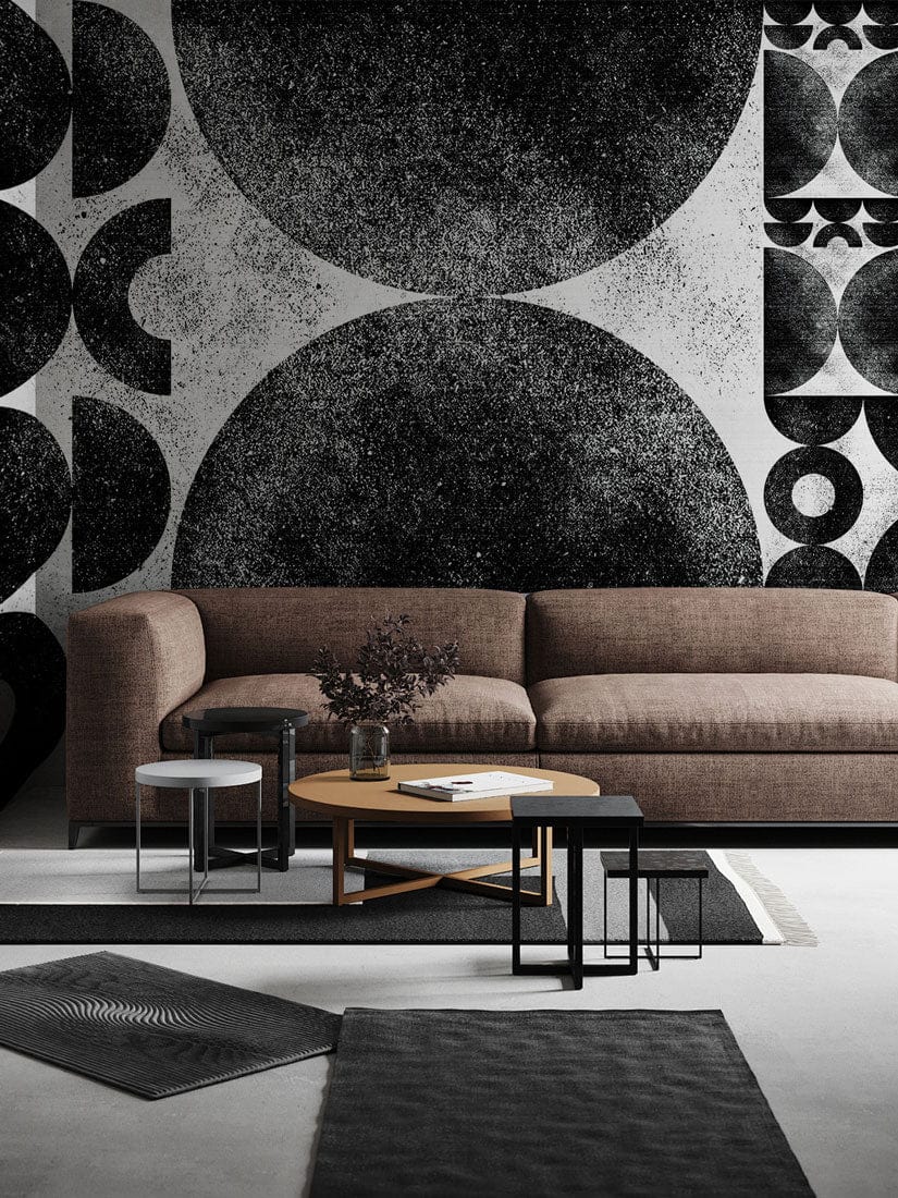 Monochrome geometric abstract wallpaper in living room featuring brown sofa, grey flooring, and minimalist decor.