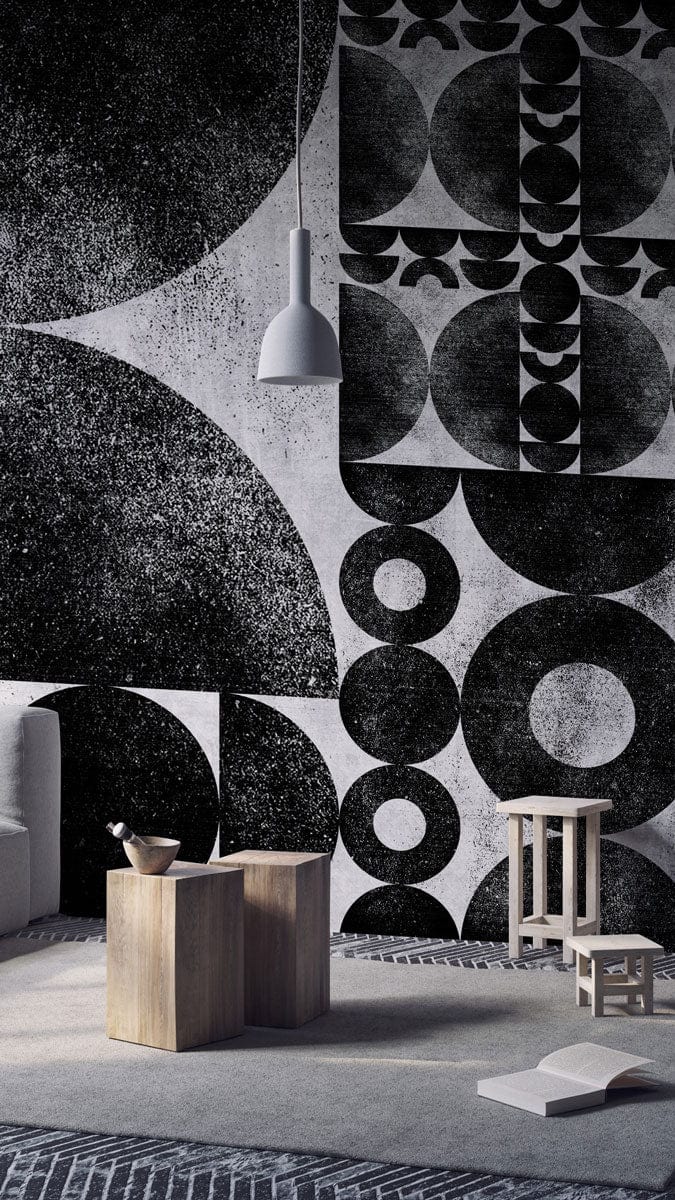 Monochrome geometric abstract wallpaper with modern art design, featuring grey sofa and wooden stools.