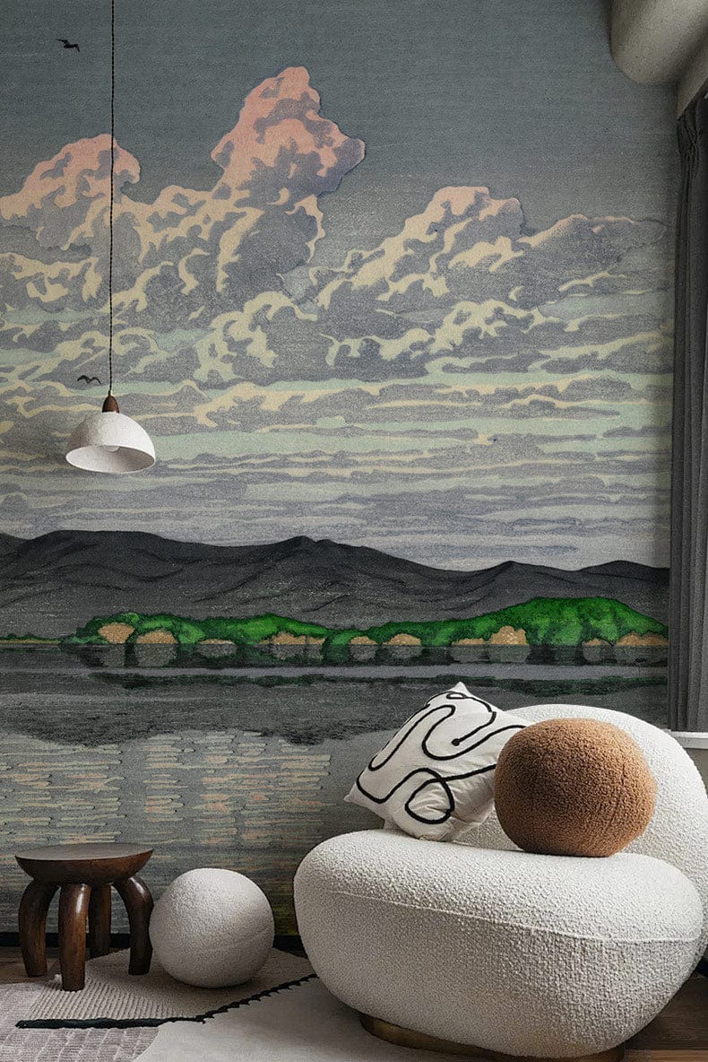 Tranquil mountain landscape wallpaper with serene pastel skies, curved white sofa, wooden side table.