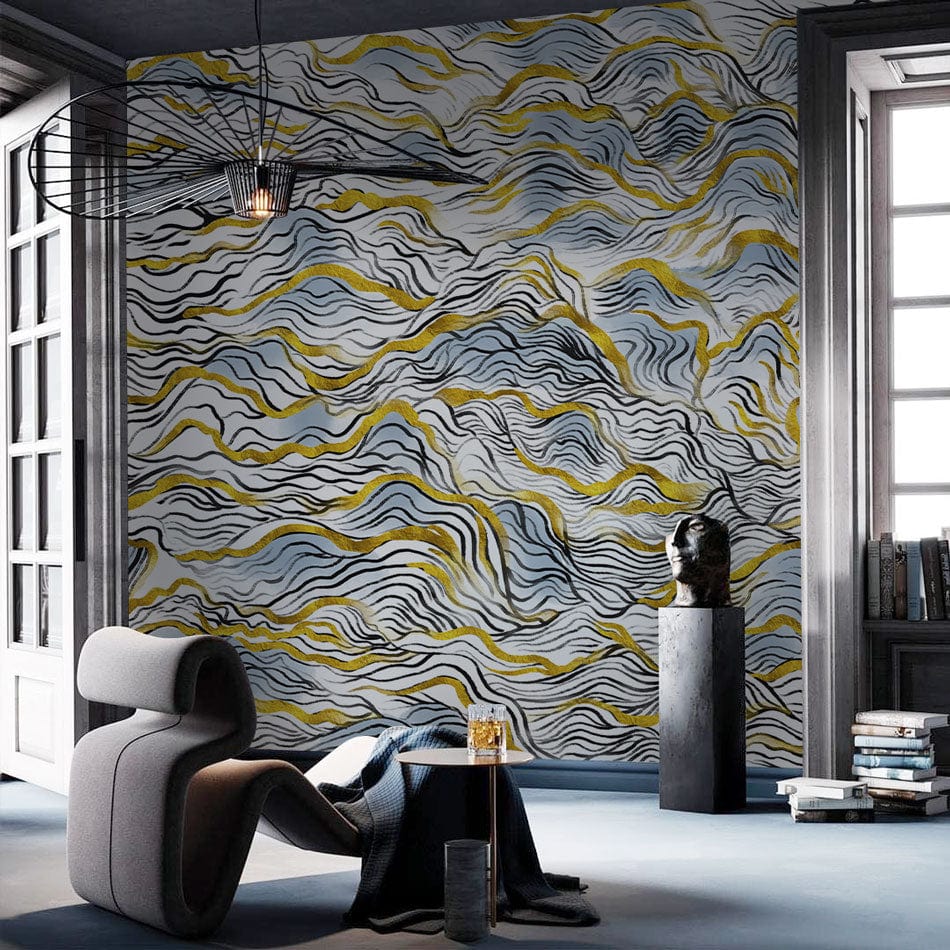 Elegant blue and gold abstract waves wallpaper mural in modern living room with grey chair and table.
