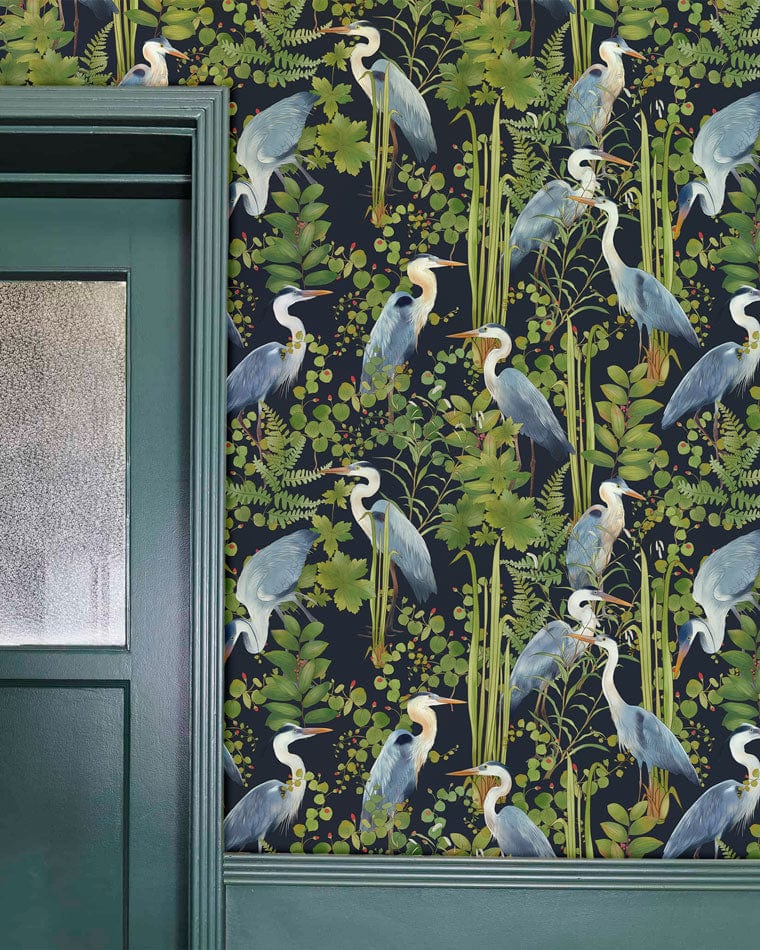 Elegant wallpaper with blue herons, green foliage, and botanical pattern by Nature-Inspired in room setting.