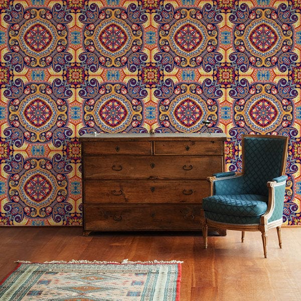 Vintage Bohemian Mandala wallpaper in earthy tones, wooden chest, blue armchair, wooden floor, rug.