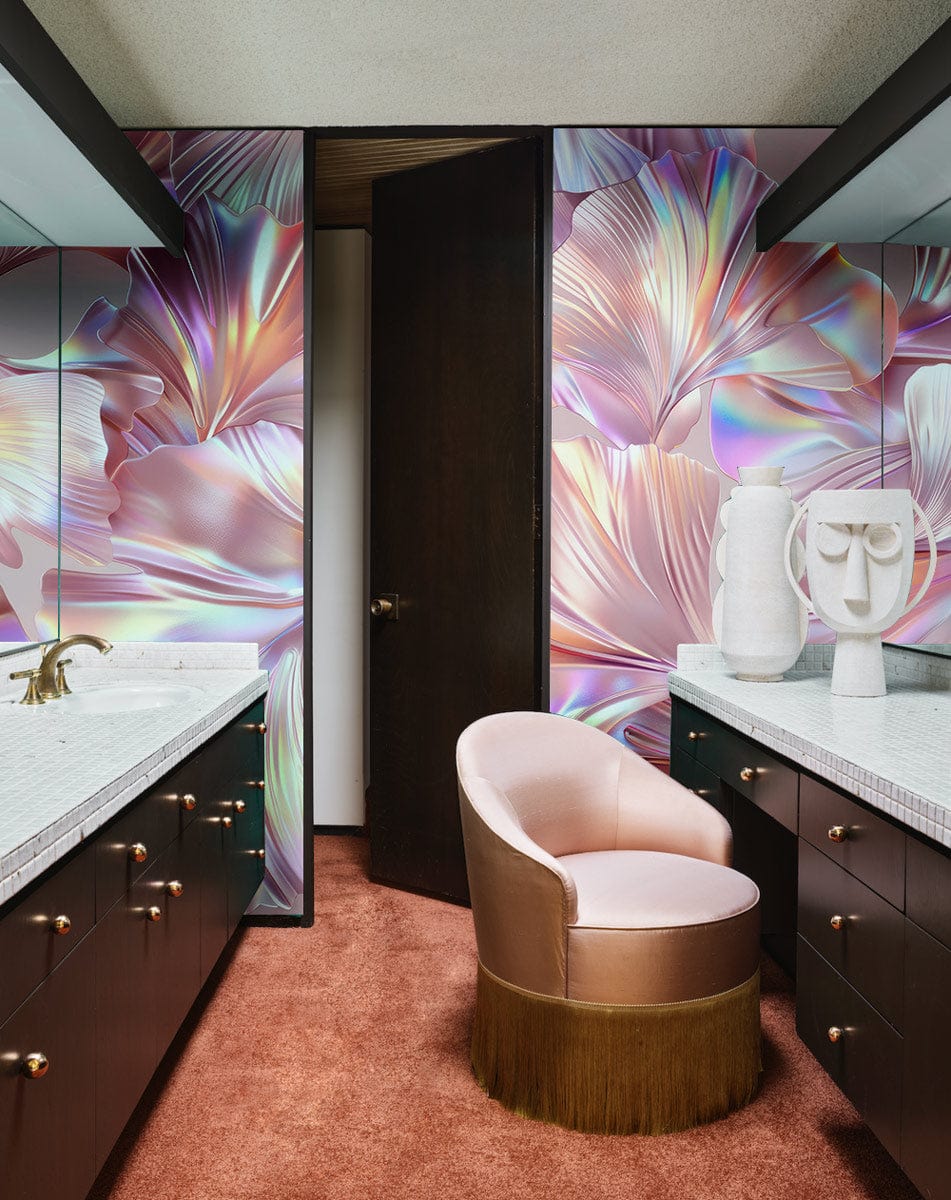 Luxurious bathroom with iridescent pink floral wallpaper, pink velvet chair, and marble countertops.