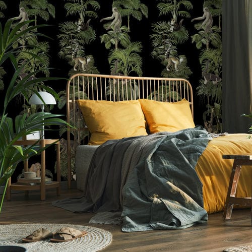 Tropical jungle safari mural wallpaper in bedroom with yellow bed linens, wooden floor, stylish decor.
