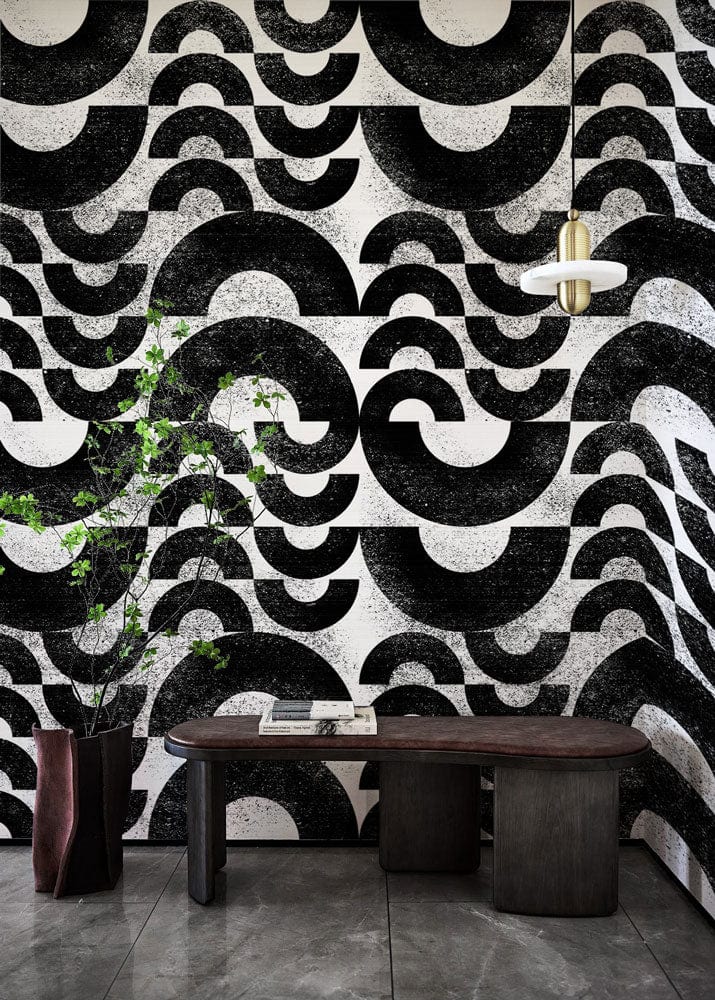 Monochrome geometric wave wallpaper with modern table and pendant light, concrete flooring, artistic decor.