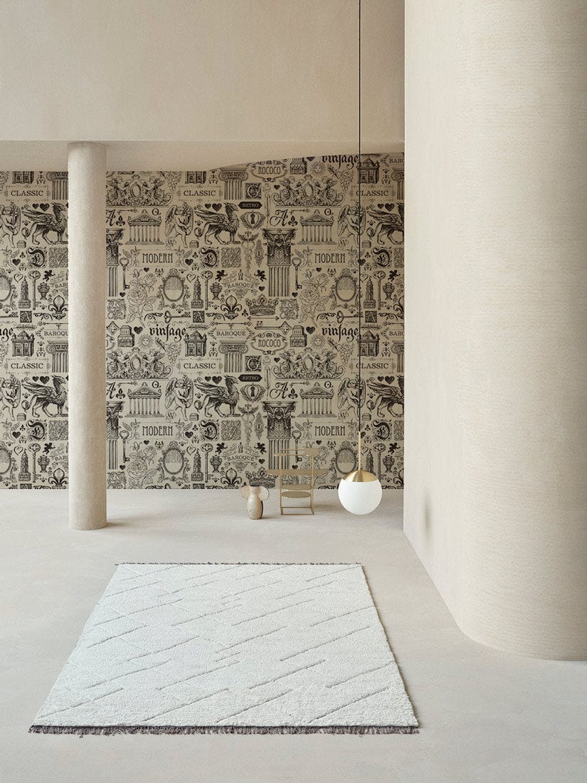 Vintage grey illustrated wallpaper in minimalist room, features cream columns, modern pendant light, light rug.