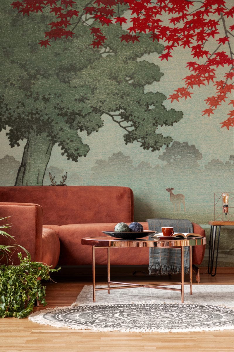 Misty Forest Deer Mural Wallpaper with red leaves, brown sofa, wooden flooring, and decorative table.