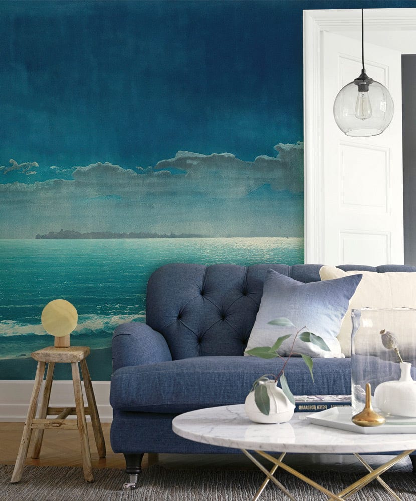 Midnight Blue Coastal Serenity Mural Wallpaper, moonlit ocean scene, blue sofa, marble coffee table.