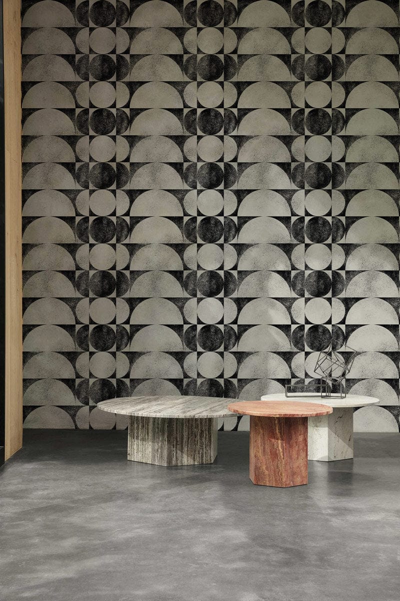 Monochrome geometric wallpaper in black and white, modern design. Marble tables, grey concrete flooring.