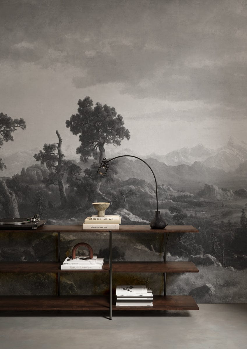 Vintage scenic mural wallpaper featuring monochrome mountains, grey wall, wooden shelves, modern floor lamp.