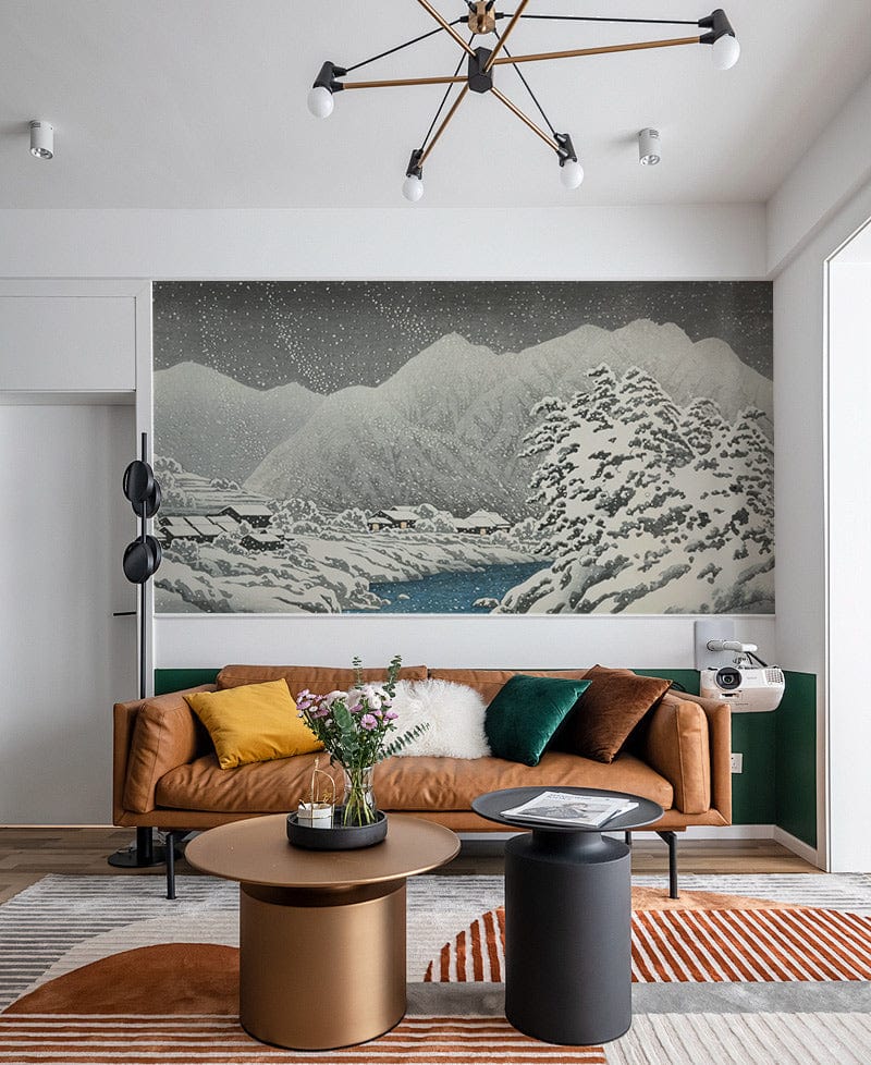 Serene snowy mountain mural wallpaper, brown sofa, modern lighting, round tables in stylish living room.